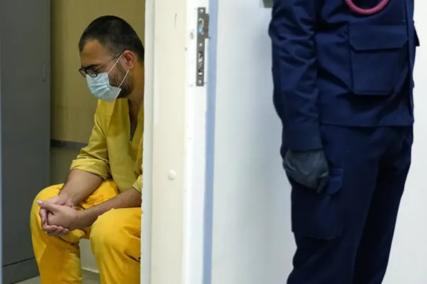 DEAŞ üyesi olduğundan şüphelenilen bir kişi, Suriye'den Irak'a nakledildikten sonra Bağdat'taki el-Karkh hapishanesinde sorgulanmak üzere getirildi (AP)