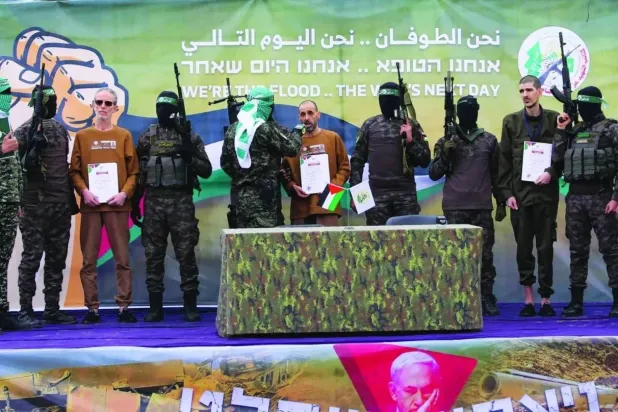 A Hamas banner reading “We Are the Flood… We Are the Day After” during the handover of a group of Israeli hostages (file photo – AFP)