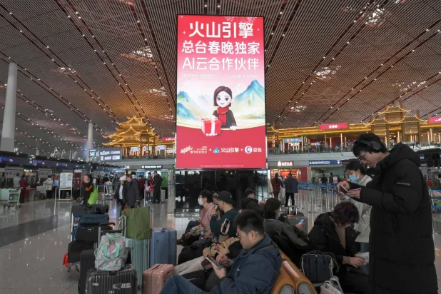 This picture taken on February 5, 2026 shows advertising promoting ByteDance's cloud and AI service platform 'Volcano Engine' and chatbot 'Doubao' at the Beijing Capital International airport in Beijing. (Photo by Adek BERRY / AFP)