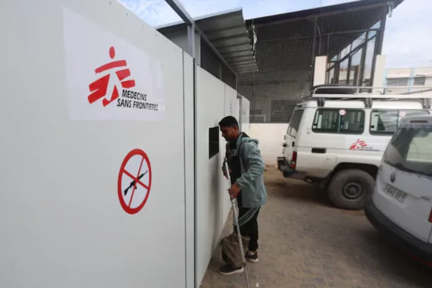 A Palestinian war-wounded man waits at the entrance, hoping to receive medical treatment, at a clinic run by medical charity Medecins Sans Frontieres (MSF), amid shortages of medical supplies, in Khan Younis, southern Gaza Strip, December 31, 2025. REUTERS/Ramadan Abed 