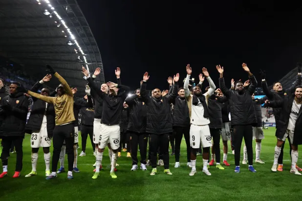 لاعبو لانس يحتفلون مع جماهيرهم بعد الفوز (رويترز)