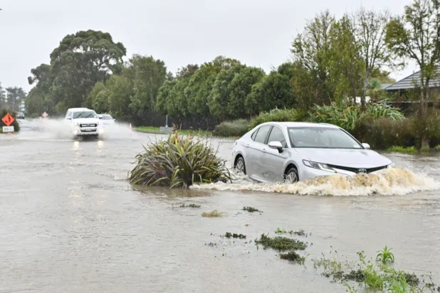 Vehicles drive through flood waters during a downpour in Lincoln at the Selwyn district in the Canterbury Region of New Zealand's South Island, May 1, 2025. (AFP)