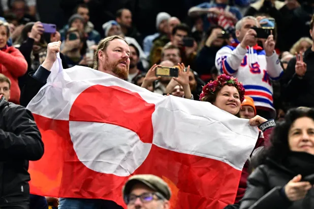  Milano Cortina 2026 Olympics - Ice Hockey - Men's Preliminary Round - Group C - United States vs Denmark - Milano Santagiulia Ice Hockey Arena, Milan, Italy - February 14, 2026. A spectator waves a Greenland flag in the stands before the match. (Reuters)