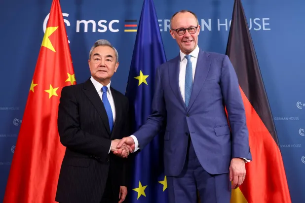  14 February 2026, Bavaria, Munich: German Chancellor Friedrich Merz (R) shakes hands with Chinese Foreign Minister Wang Yi for a joint meeting on the sidelines of the Munich Security Conference. (Thilo Schmuelgen/Reuters/Pool/dpa)