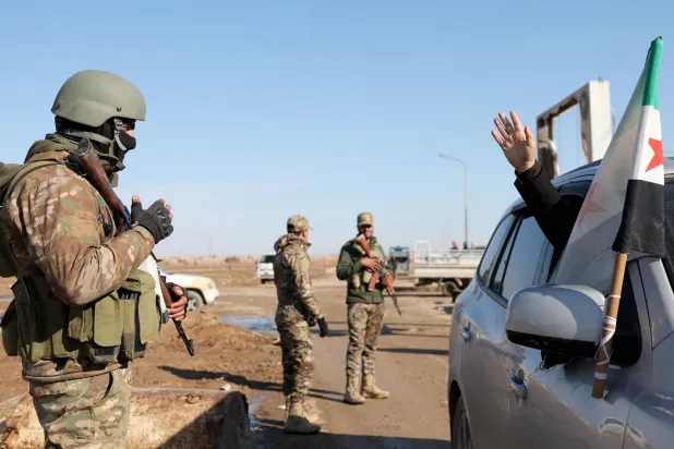 مواطن من الشدادي في جنوب الحسكة يلوّح لجنود من الجيش السوري بعد سيطرتهم على المدينة الشهر الماضي (أ.ف.ب)