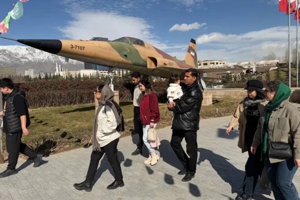 Tahran’da bir askeri müzeyi ziyaret eden İranlılar, İran Hava Kuvvetleri’ne ait Amerikan yapımı F-5 savaş uçağının önünden geçiyor, 13 Şubat 2026 (AP)