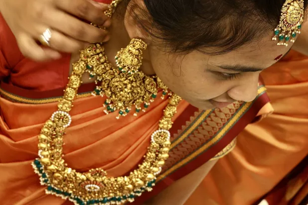 An Indian woman tries on gold jewelry at a jewelry store in Bangalore (EPA)