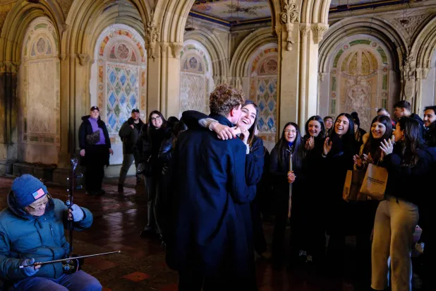 A couple dances next to a street musician in Central Park on Valentine's day in New York, on February 14, 2026. (Photo by Charly TRIBALLEAU / AFP)