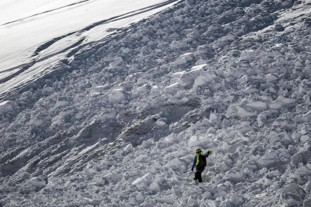 A member of the CRS Alpes Grenoble mountain rescue team operates as he searches for potential buried victims during an avalanche emergency response rescue mission in an off-piste area of the Ecrins massif, French Alps on January 29, 2026. (Photo by JEFF PACHOUD / AFP)