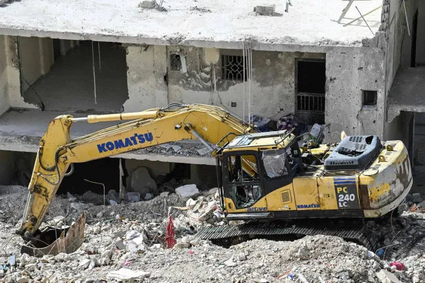 حفارة متضررة تقف على أنقاض مبنى تعرّض لضربة جوية إسرائيلية في قرية قناريت جنوب لبنان... 16 فبراير 2026 (أ.ف.ب)