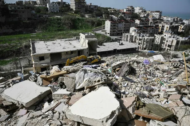 A damaged excavator sits on the rubble of a building that was hit in January by an Israeli strike in the southern Lebanese village of Qannarit, on February 16, 2026. (AFP)