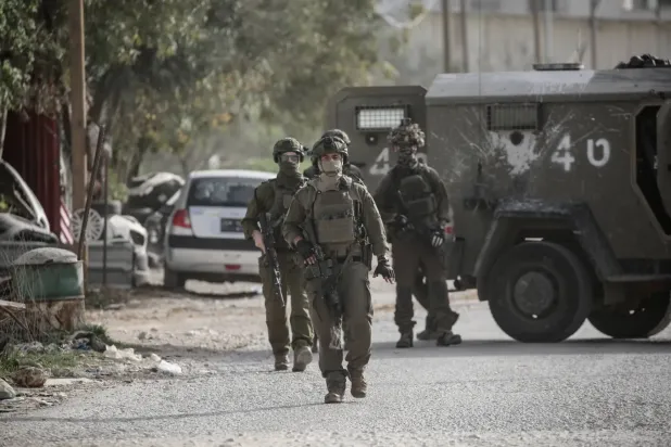 İsrail askerleri, Filistin ordusunun gerekli izinlere sahip olmadıkları gerekçesiyle Awarta kontrol noktası yakınlarındaki bir Filistin dükkanını ve oto tamir atölyesini yıkması sırasında güvenlik önlemleri alıyor (DPA)