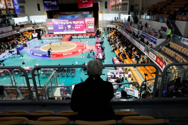 An elderly spectator watches a ssireum match during a Lunar New Year Ssireum championship at the Taean Complex Indoor Gymnasium in Taean, South Korea, February 14, 2026. (Reuters)