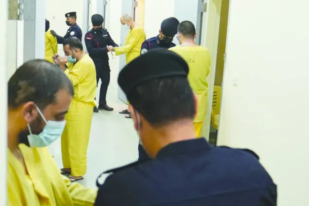 عناصر من «داعش» أثناء إيداعهم سجن الكرخ المركزي ببغداد (أ.ب)