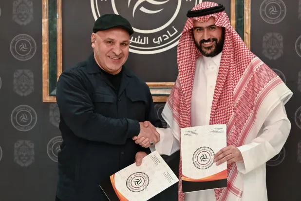 بن زكري يصافح عبد العزيز المالك رئيس الشباب بعد توقيع العقد (موقع النادي)