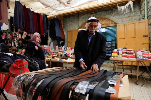 A Palestinian man checks leather belts as people prepare for Ramadan, in the old city of Hebron in the Israeli-occupied West Bank, February 17,2026. (Reuters)