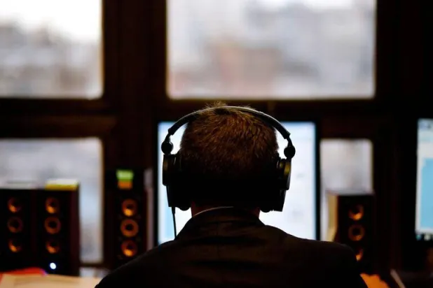 رجل يرتدي سماعات أذن خلال تأدية عمله (رويترز)