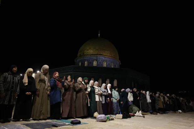 تؤدي نساء فلسطينيات صلاة التراويح في الليلة الأولى من شهر رمضان المبارك قرب قبة الصخرة في المسجد الأقصى بالبلدة القديمة في القدس (أ.ف.ب)