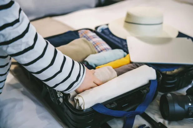 لف الملابس طريقة جيدة لتوضيب حقيبة السفر (شاترستوك)