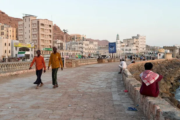 السكان المحليون يتنزهون على طول الساحل في مدينة المكلا الساحلية بحضرموت (رويترز)