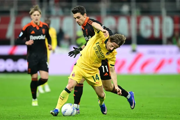 مودريتش يتعثر في إحدى هجمات الميلان (رويترز)