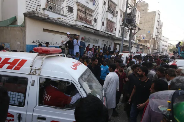 Rescue workers and people gather at the site of a residential compound following a suspected gas leakage blast in Karachi, Pakistan, 19 February 2026. EPA/REHAN KHAN

