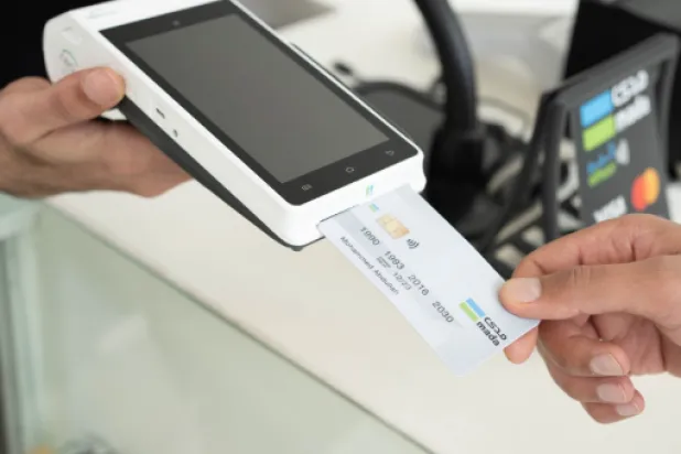 أحد الأشخاص يستخدم بطاقة «مدى» لدفع مبلغ مالي عبر جهاز نقاط البيع (مدى)