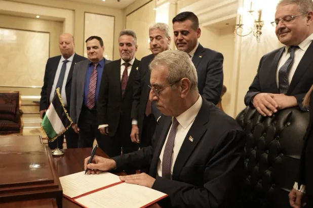 رئيس لجنة التكنوقراط الفلسطينية المكلّفة بإدارة شؤون قطاع غزة علي شعث يوقع بيان مهمة اللجنة الوطنية لإدارة القطاع (حسابه عبر منصة «إكس») 