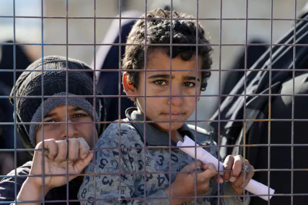 Children, part of a group of detainees, look through a fence at al-Hol camp after the Syrian government took control of it following the withdrawal of Syrian Democratic Forces (SDF), in Hasaka, Syria, January 21, 2026. REUTERS/Khalil Ashawi 