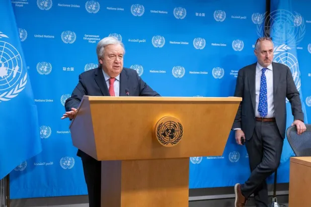 الأمين العام للأمم المتحدة أنطونيو غوتيريش خلال مؤتمر صحافي وخلفه ستيفان دوجاريك المتحدث باسم المنظمة الأممية (الأمم المتحدة)