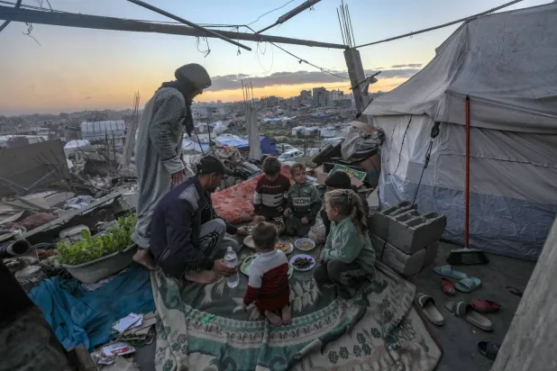 Filistinli bir aile, Gazze Şeridi'nin kuzeyindeki Cibaliye'de çadırlarının önünde kahvaltı yapıyor (EPA)