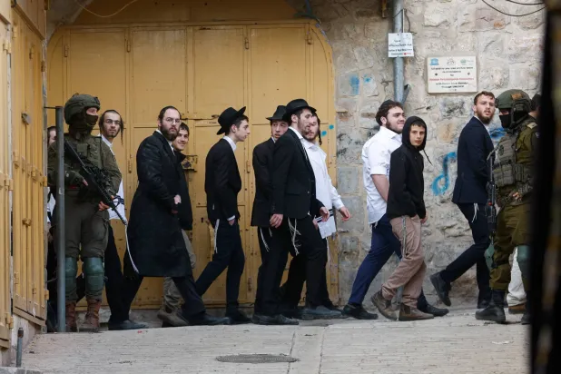 جنود إسرائيليون يقفون في دورية حراسة خلال جولة أسبوعية للمستوطنين الإسرائيليين في الخليل بالضفة الغربية المحتلة 14 فبراير 2026 (رويترز)