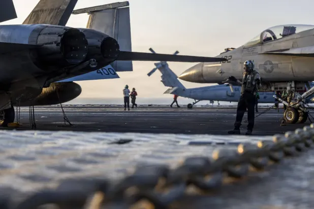 ABD Donanması tarafından yayınlanan bir fotoğrafta, Arap Denizi'ndeki USS Abraham Lincoln uçak gemisinin güvertesinde bir teknisyenin savaş uçağı kullandığı görülüyor (ABD Donanması)