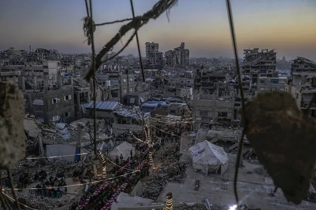 Palestinians gather between destroyed houses to break their fast together during the holy month of Ramadan in the northern Gaza Strip, 20 February 2026. (EPA)