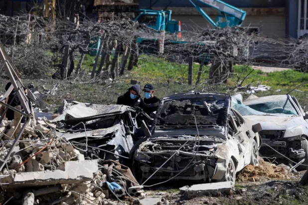 أشخاص يتفقدون الأضرار في موقع الغارة الإسرائيلية على وادي البقاع شرق لبنان (رويترز)