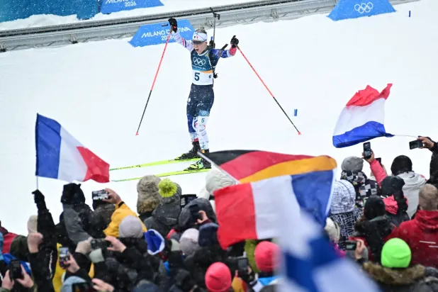 أوسيان ميشلون تحتفل مع الجماهير الفرنسية بذهبية الانطلاق الجماعي (إ.ب.أ)