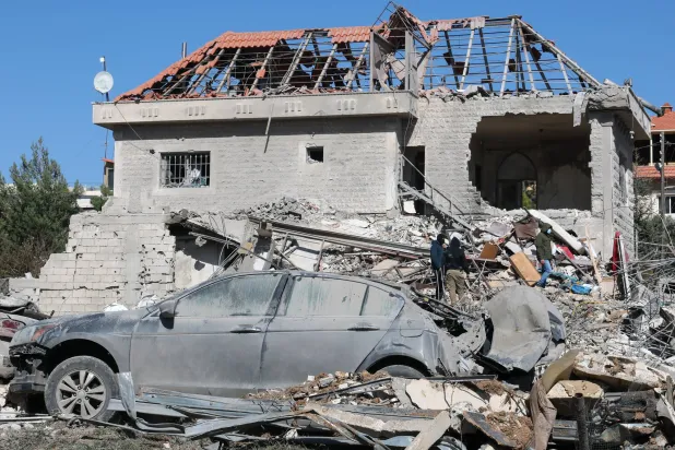 People gather near a building damaged in an Israeli strike in the village of Bednayel in eastern Lebanon, 21 February 2026. EPA/WAEL HAMZEH