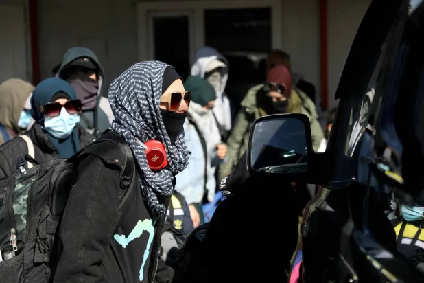 أفراد من عائلات أسترالية يُعتقد ارتباطها بمسلحي تنظيم «داعش» يغادرون مخيم روج قرب ديريك بسوريا في 16 فبراير2026 (رويترز)