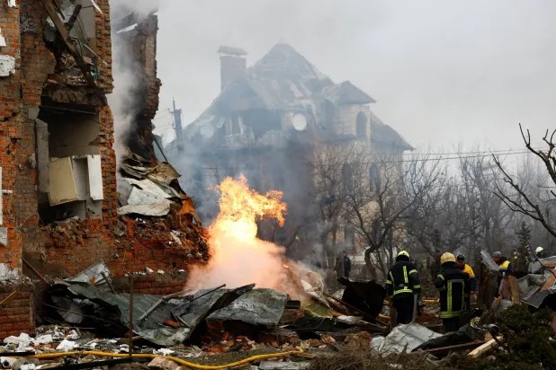 رجال إطفاء أوكرانيون أمام مبنى سكني تضرر جراء الغارات الروسية على كييف (رويترز)