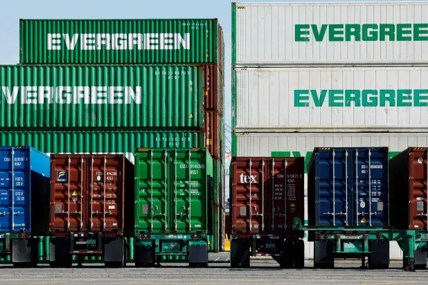 حاويات شحن مكدسة بينما تستقر أخرى على هياكل شاحنات نقل في ميناء لوس أنجليس (أ.ف.ب)