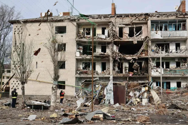 تظهر هذه الصورة التي التقطها ونشرها المكتب الصحافي لـ«اللواء الآلي 65» التابع للقوات المسلحة الأوكرانية يوم 20 فبراير 2026 عناصر إنفاذ القانون الأوكرانيين وهم يقفون بين الأنقاض أمام مبنى سكني متضرر عقب غارة جوية في كوميشوفاخا بمنطقة زابوريجيا (أ.ف.ب)