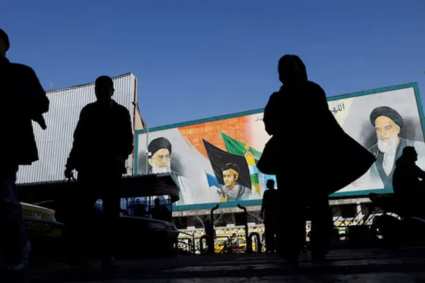 People walk near a mural featuring images of Iran's Supreme Leader Ayatollah Ali Khamenei and leader of Iran's 1979 Islamic Revolution Ayatollah Ruhollah Khomeini, on a street in Tehran, Iran, February 17, 2026. Majid Asgaripour/WANA (West Asia News Agency) via REUTERS 