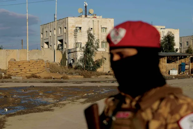 A Syrian government soldier outside Al-Aqtan prison in Raqqa, which holds ISIS detainees (AFP)
