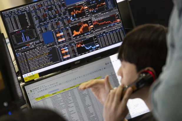 متداول كوري جنوبي يعمل أمام شاشات تعرض مؤشرات الأسهم ببنك هانا في سيول (إ ب أ)