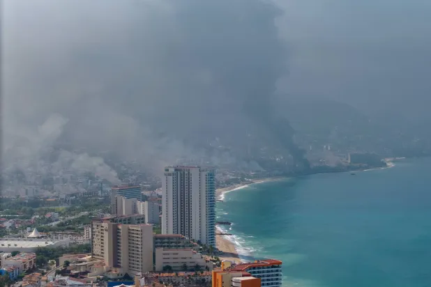 صورة جوية تظهر الدخان المتصاعد جراء ردود الفعل العنيفة على مقتل «إل منتشو» زعيم عصابة «خاليسكو نيو جينيريشن» في المكسيك (إ.ب.أ)