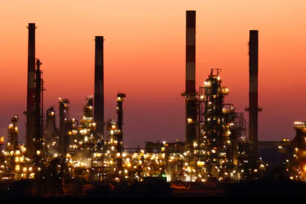 The chimneys of the Total Grandpuits oil refinery are seen just after sunset, southeast of Paris, France, March 1, 2021. REUTERS/Christian Hartmann 