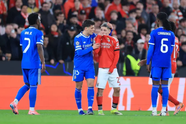 SL Benfica's Argentine forward #25 Gianluca Prestianni hides his mouth while arguing with Real Madrid's Brazilian forward #07 Vinícius Júniorwho complained about alleged racists insults during the UEFA Champions League knockout round play-off first leg football match between SL Benfica and Real Madrid CF at Estadio da Luz in Lisbon on February 17, 2026. (AFP) 