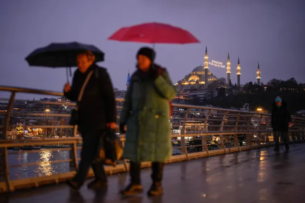 People walk with the Suleymaniye Mosque in the background ahead of the holy month of Ramadan in Istanbul, Wednesday, Feb. 18, 2026. (AP) 