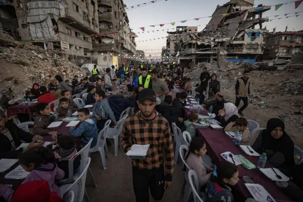Palestinians share the iftar meal amid homes destroyed by Israeli bombardment in Gaza on Sunday (EPA). 