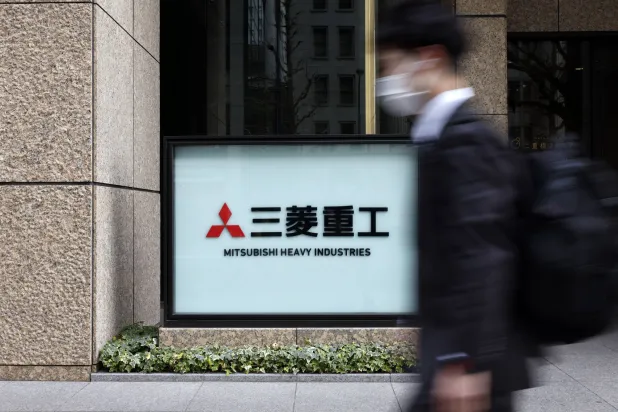 رجل يمر أمام مقر شركة «ميتسوبيشي» للصناعات الثقيلة في العاصمة اليابانية طوكيو (إ.ب.أ)